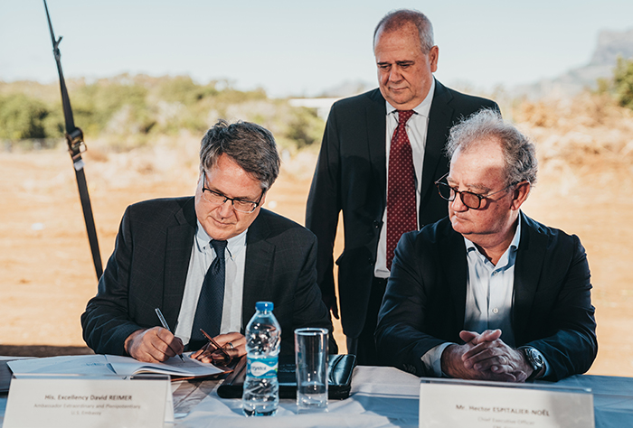 U.S. Ambassador David Reimer signing the deed of sale, alongside Hector Espitalier-Noël CEO of ENL Group